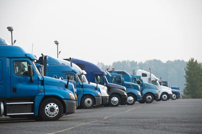 A fleet of blue and white semi-truck cabs